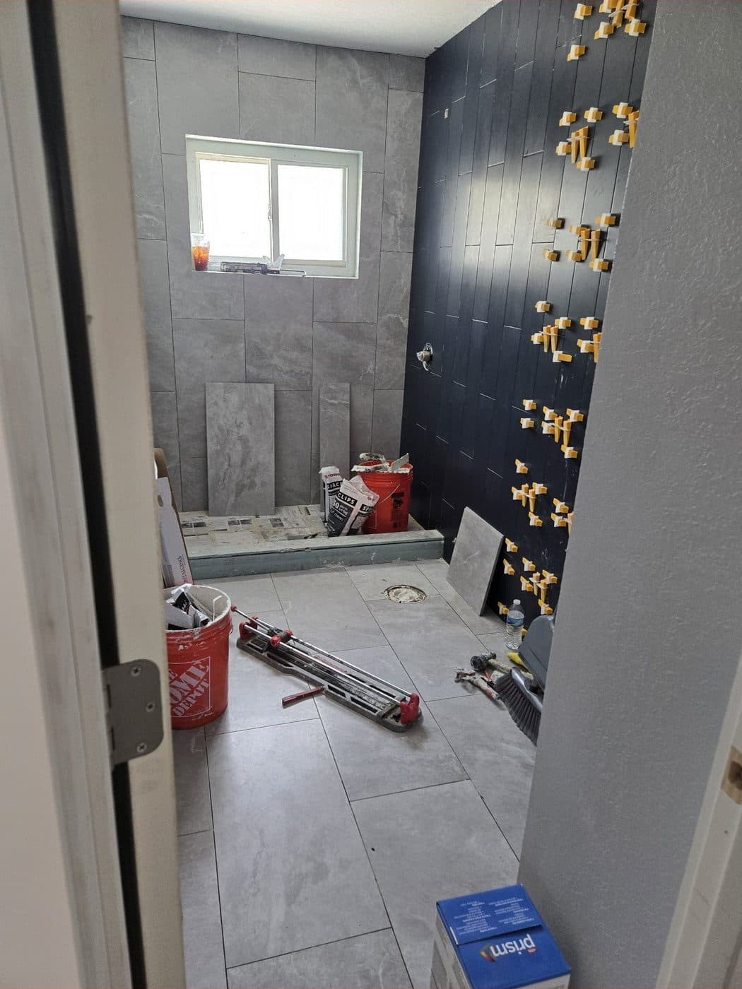 Ducha de porcelanato gris con pared de acento azul marino en patrón vertical — En proceso